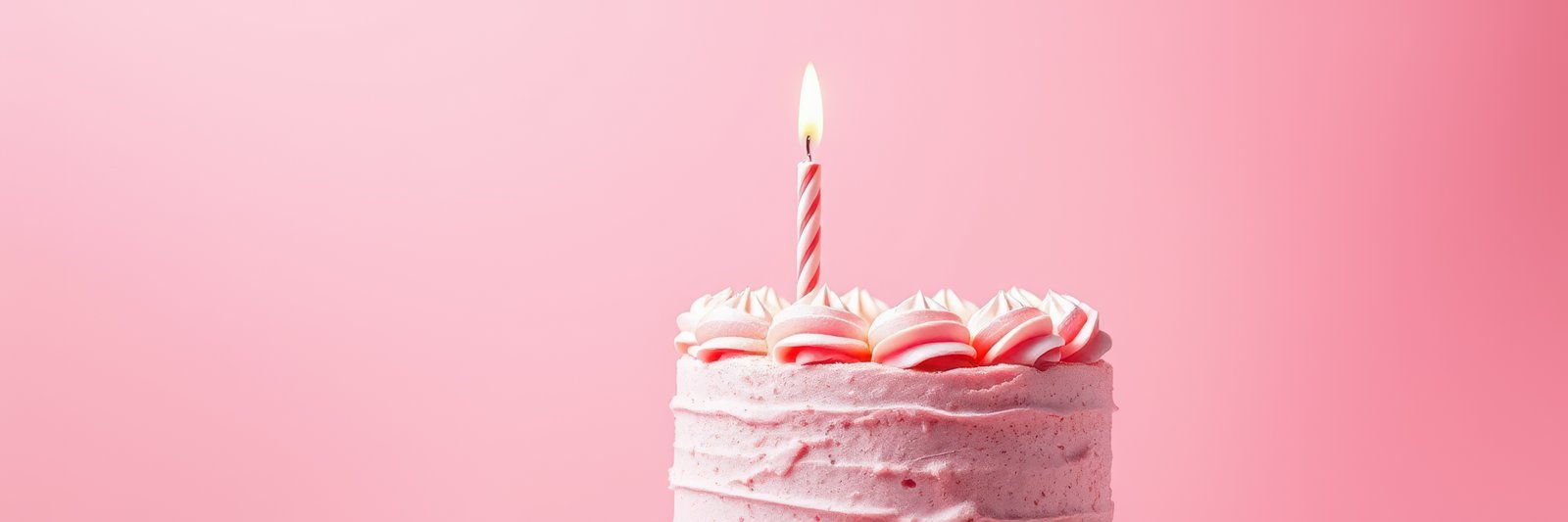 Celebrating a special occasion with a pink birthday cake adorned with a lit candle against a soft pastel background